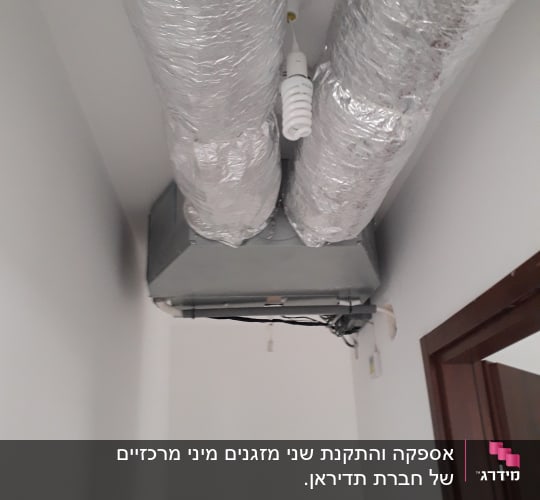 צינורות מיזוג אוויר מכוסים בנייר כסף בתקרה